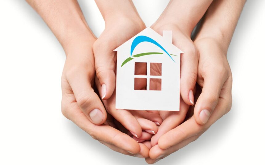 le mani di un uomo e una donna tengono una sagoma di una casa