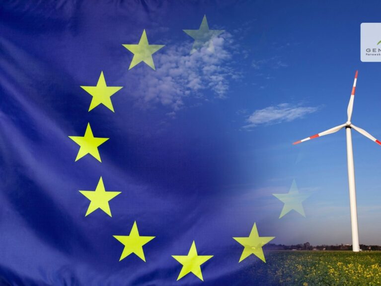 la bandiera dell'Unione Europea campeggia a fianco di una pala eolica